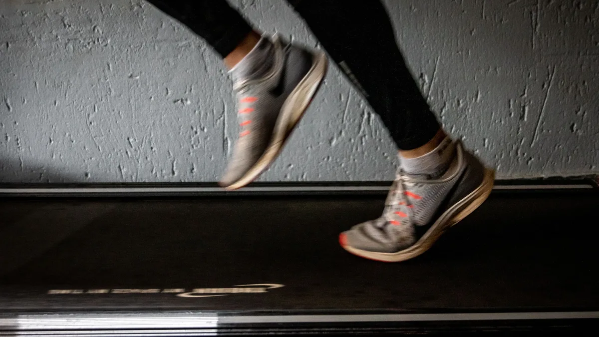 A person's legs in motion on a treadmill.