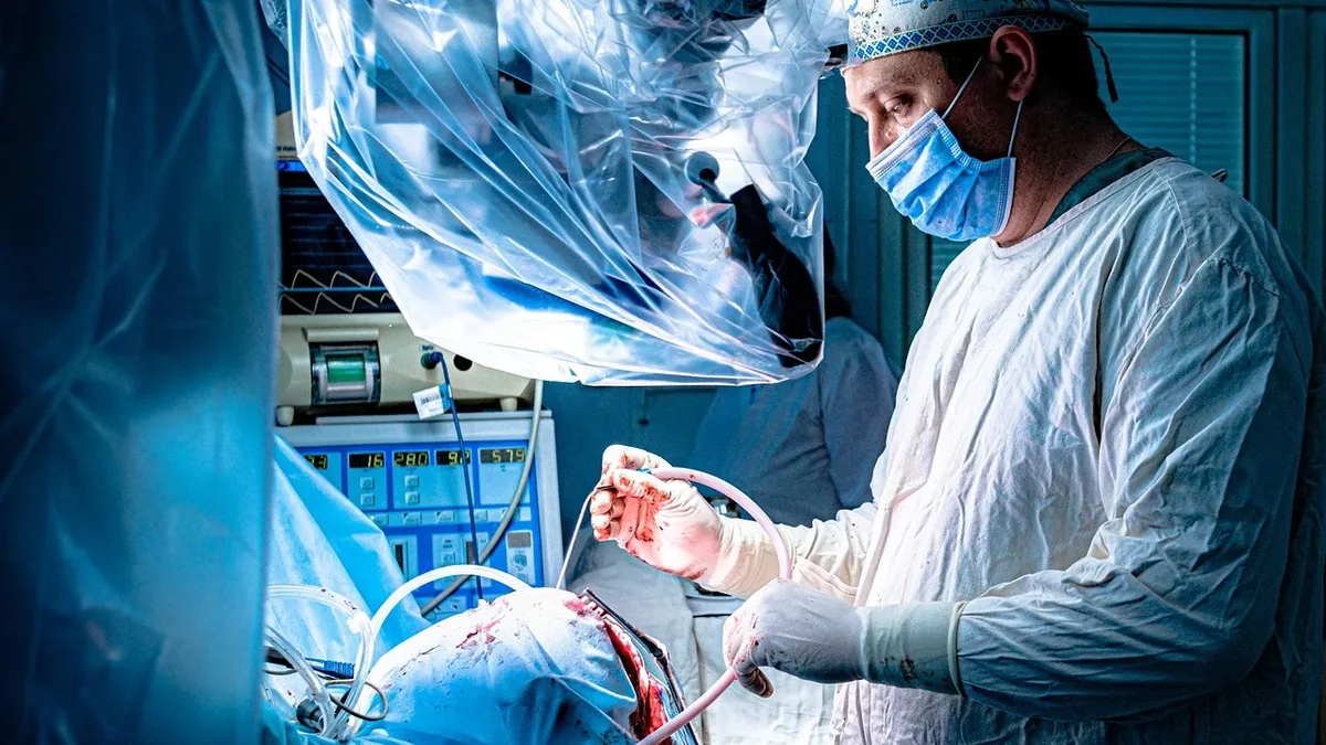 A medical professional in a surgical setting is shown performing surgery on a patient.